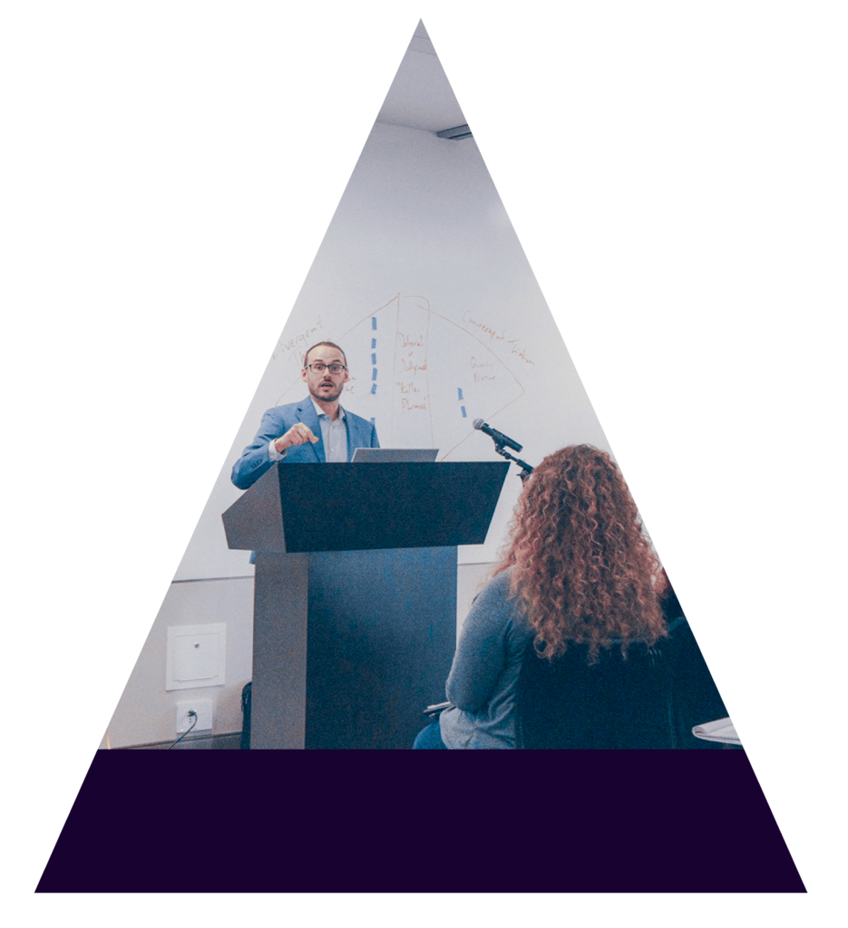 Image of Dr. Tad Dickel behind a podium speaking to a crowd